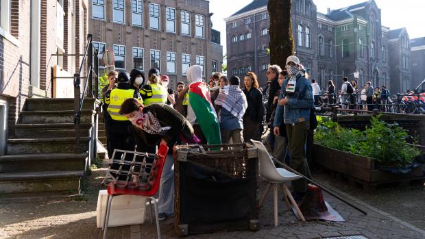 Barricades
Zeker 250 demonstranten zijn bezig om het gebied rondom de voormalige Academische Club, die zij nu zeggen bezet te hebben, te barricaderen. Daarvoor halen ze materiaal van de bouwplaats van de nieuwe UB.
&nbsp;
UvA-medewerker Paul Koopman, lid van de Ondernemingsraad van de Faculteit der Geesteswetenschappen, komt uit een vergadering waar hij te horen heeft gekregen dat de Centrale Ondernemingsraad van de UvA morgenochtend met een oproep zal komen aan het bestuur van de UvA om geen politie op de universiteit in te zetten. &lsquo;Geen geweld op de UvA&rsquo;, stelt Koopman ook.